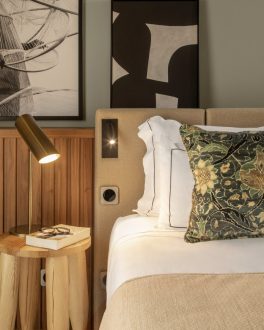 Cama de hotel feita, com almofadas brancas e uma cabeceira de padrão preto e branco/home/klevieco/fontinha.klevie.com